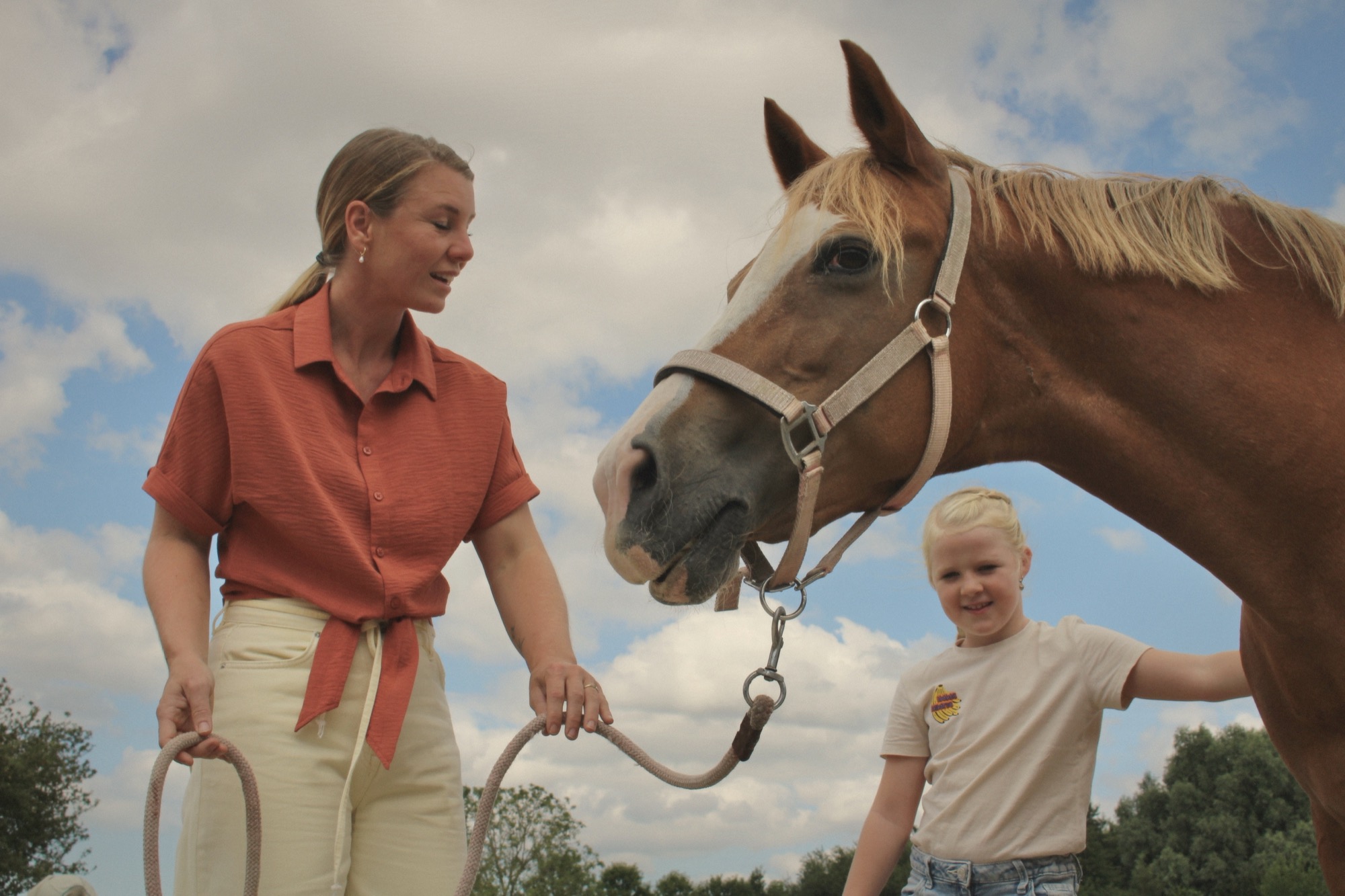 Een meisje leidt een paard over het terrein van Gijsewijs